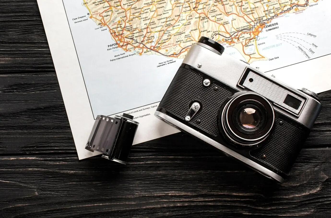 Draufsicht auf ein Reiseset mit einer Kamera auf einer Landkarte.
