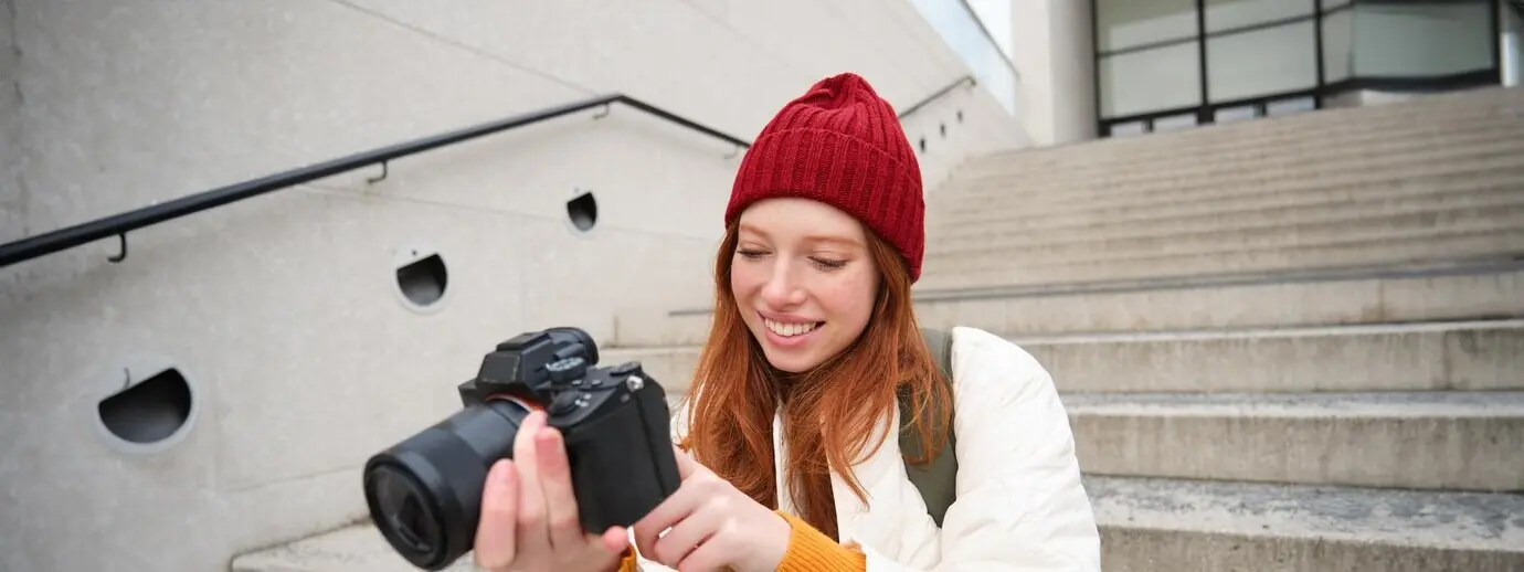 Porträt einer Fotografin, die mit einer professionellen Kamera durch die Stadt geht und fotografiert.